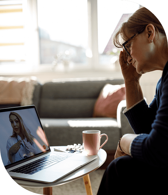 Woman video calling doctor on laptop screen.