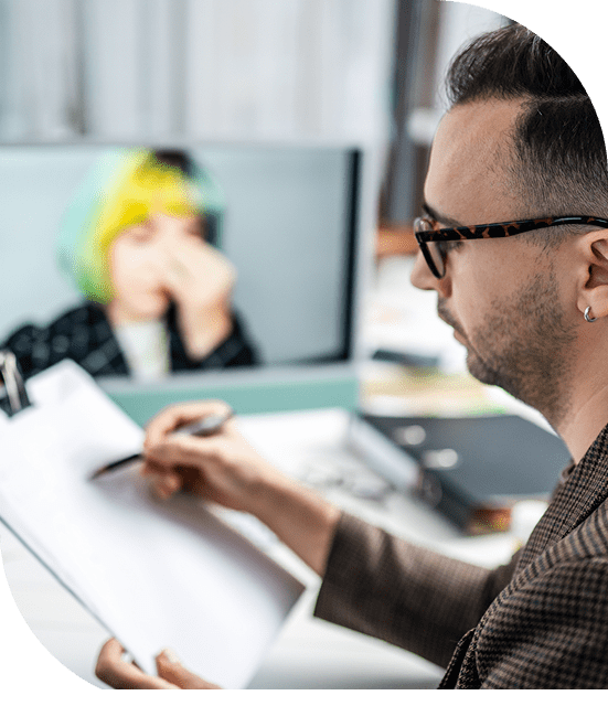 Man writing notes during a video call.
