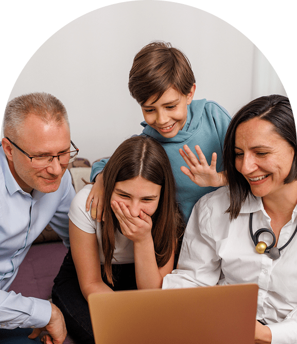 Family smiling while looking at laptop.