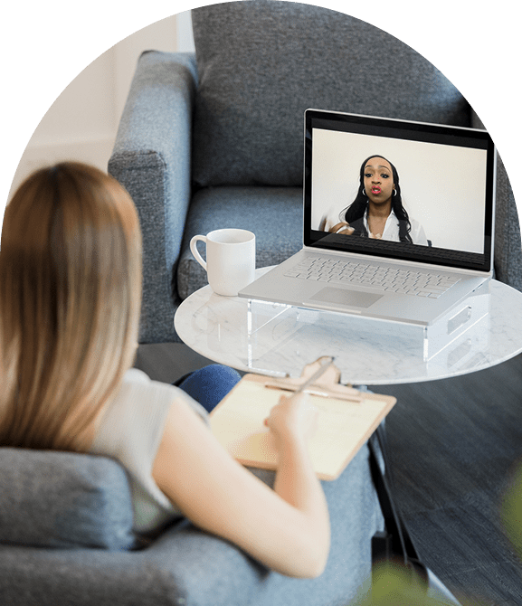Woman on video call taking notes.
