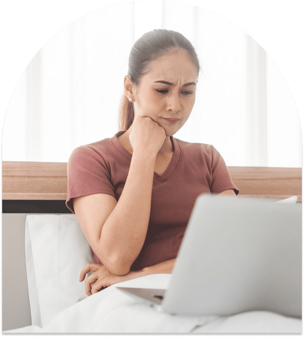 Person looking at laptop with thoughtful expression.